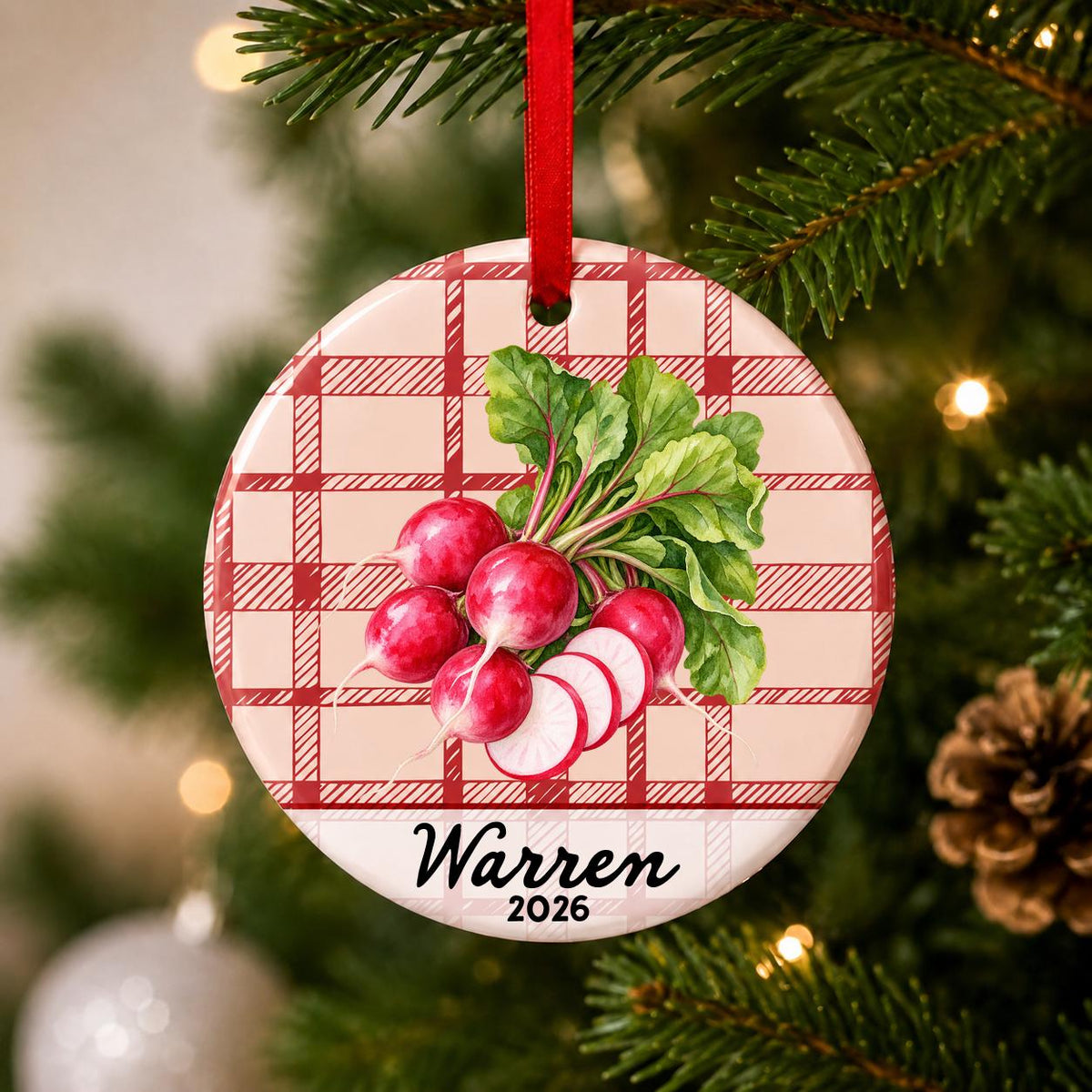Close-up of the personalized radishes ceramic ornament with name and year on red plaid hanging on a Christmas tree
