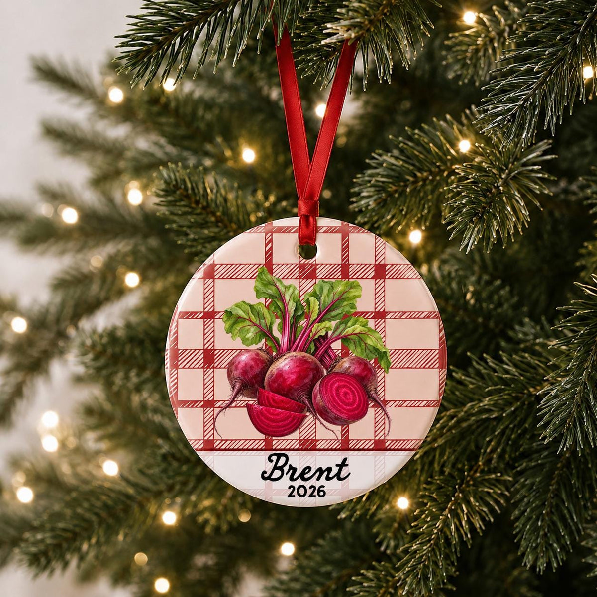 Personalized beets ceramic ornament with name and year on red plaid hanging on a lit Christmas tree