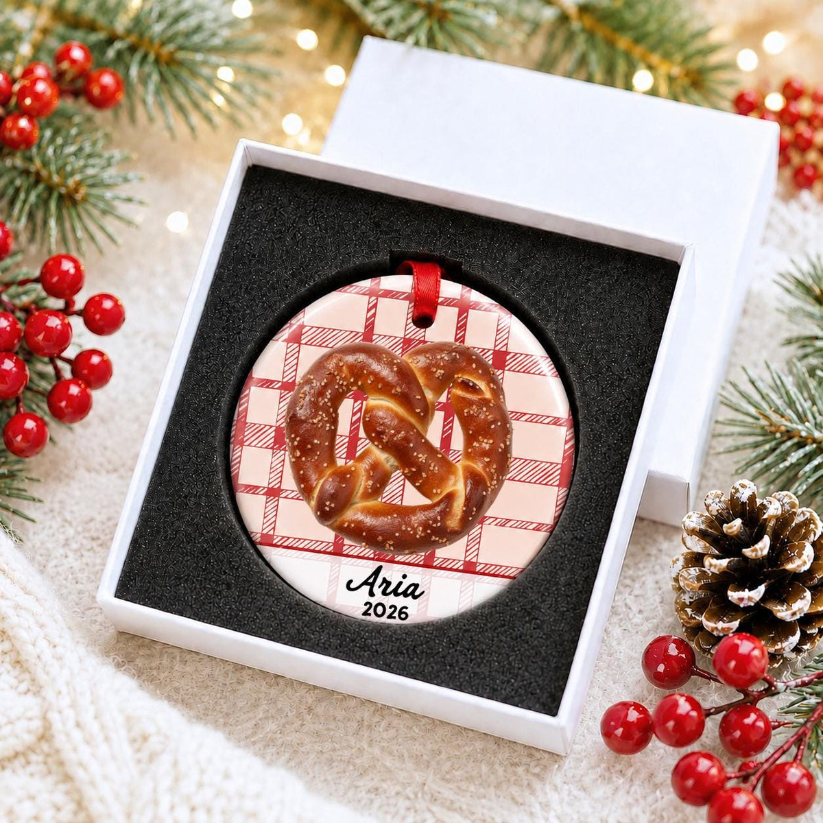 Personalized soft pretzel ceramic ornament with name and year on red plaid in a white gift box with protective foam