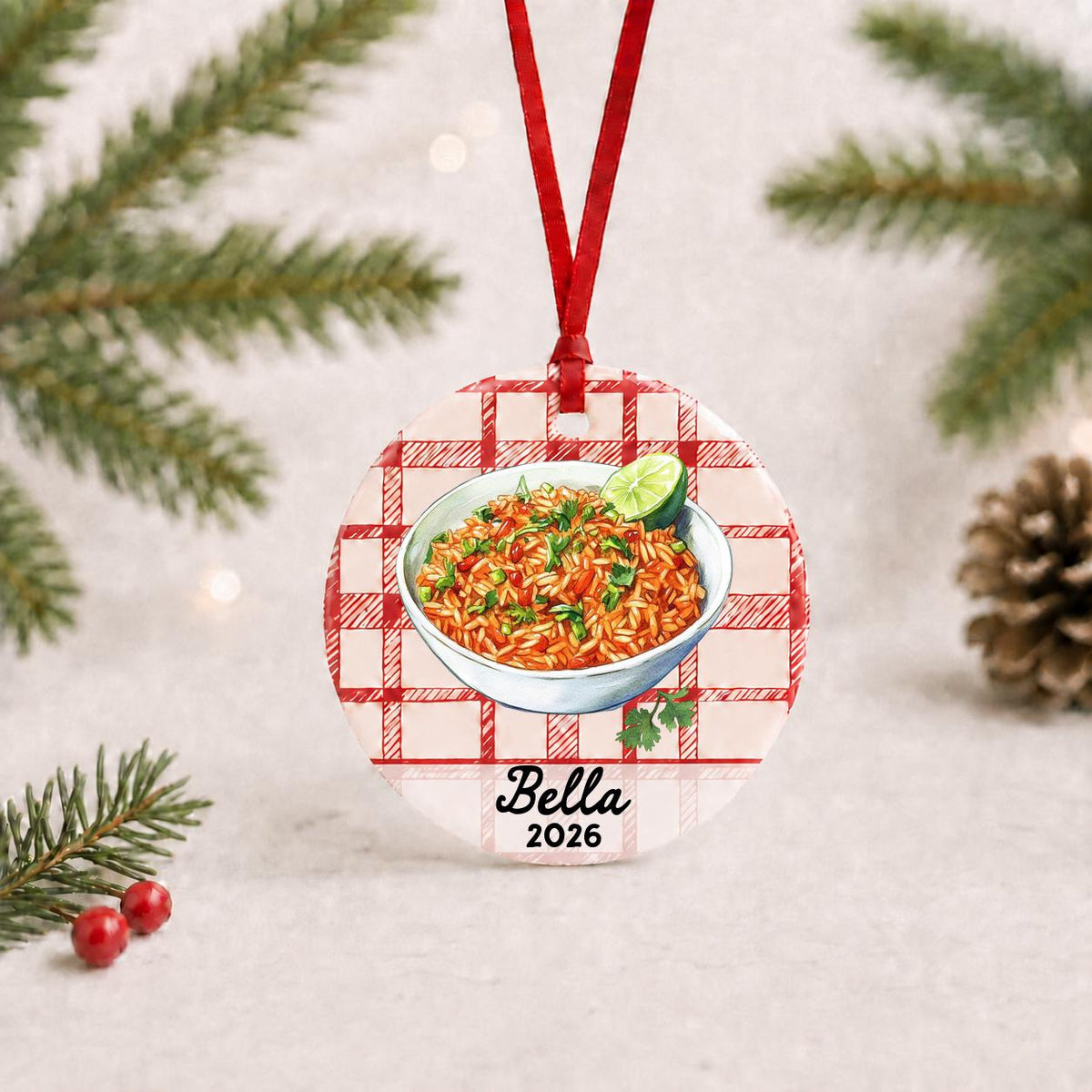 Personalized Mexican rice ceramic ornament with name and year on red plaid with red ribbon on a white surface with pine branches and pinecones