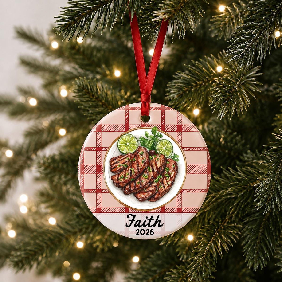 Personalized carne asada ceramic ornament with name and year on red plaid hanging on a lit Christmas tree