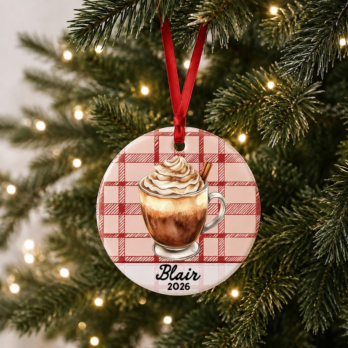 Personalized Mexican hot chocolate ceramic ornament with name and year on red plaid hanging on a lit Christmas tree