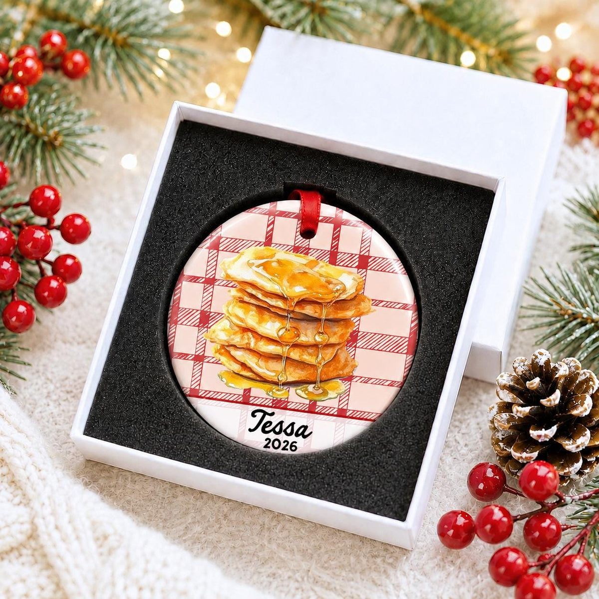 Personalized buñuelos ceramic ornament with name and year on red plaid in a white gift box with protective foam