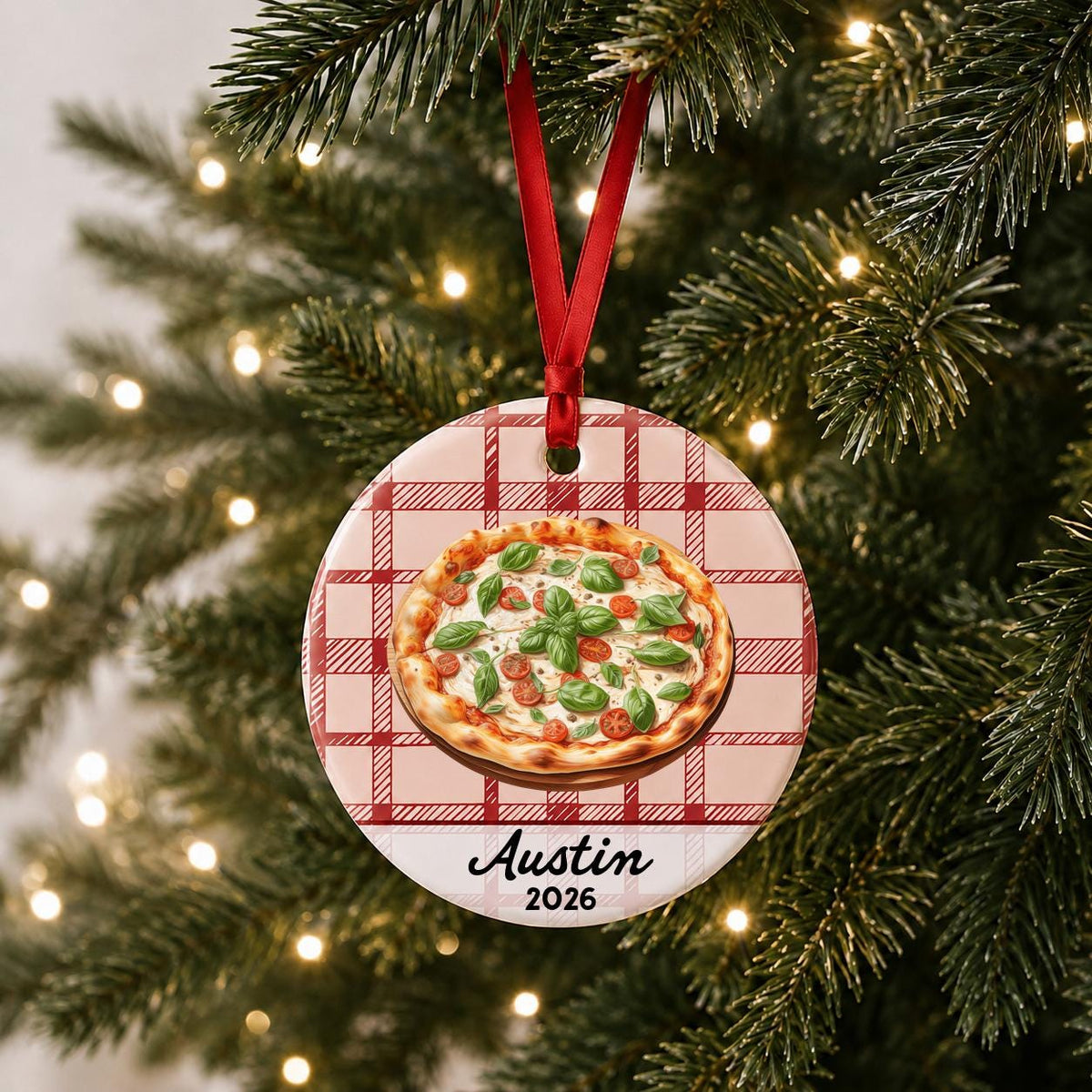 Personalized Margherita pizza ceramic ornament with name and year on red plaid hanging on a lit Christmas tree