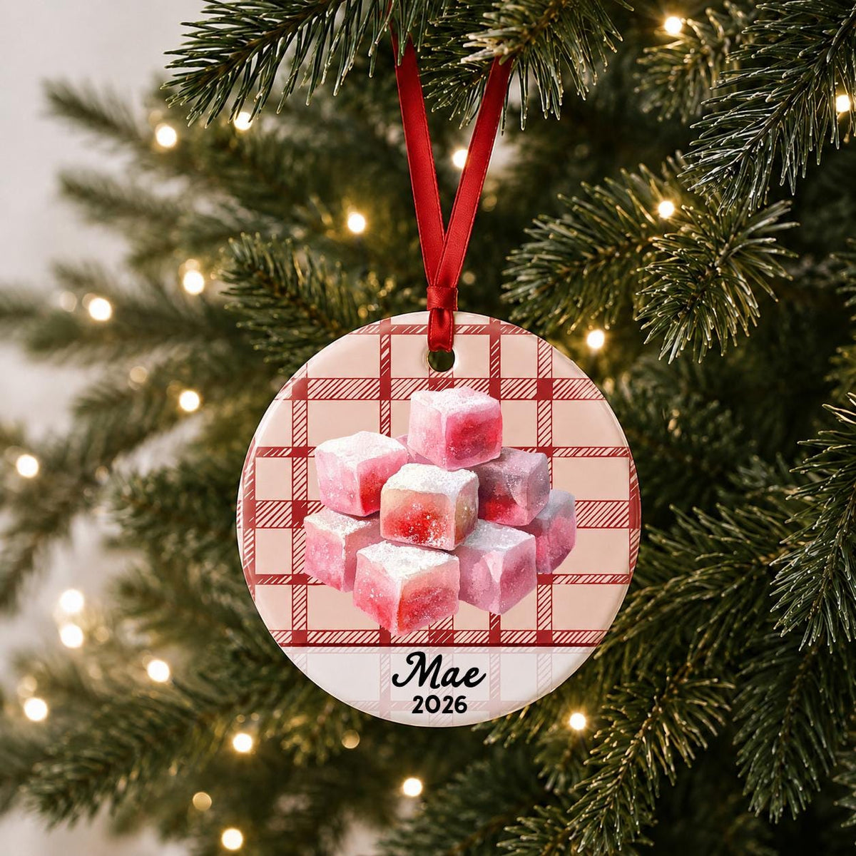 Personalized turkish delight ceramic ornament with name and year on red plaid hanging on a lit Christmas tree