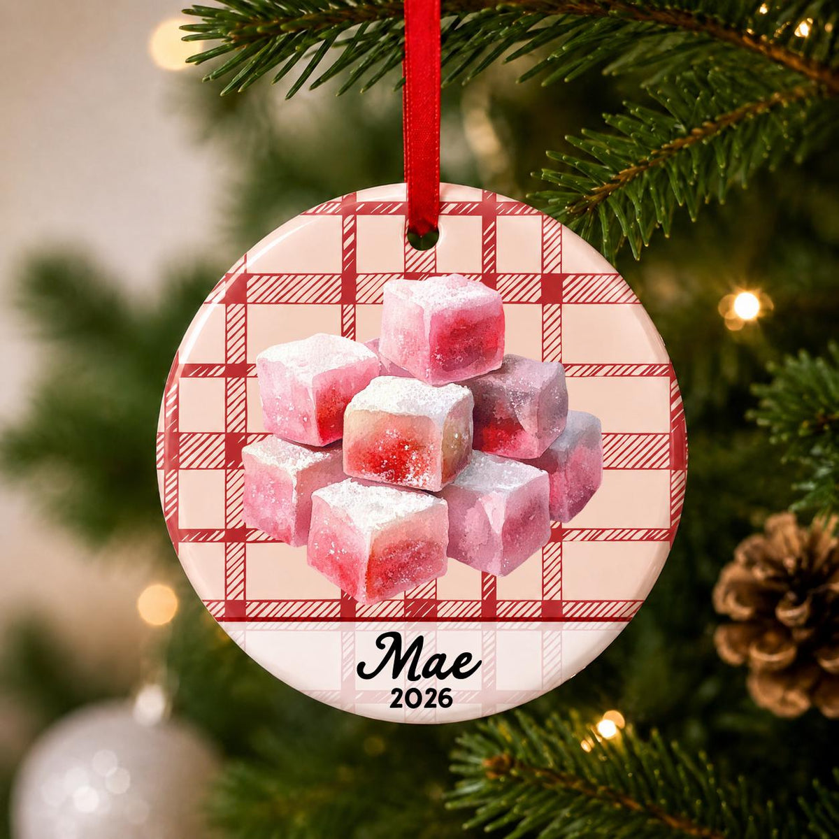 Close-up of the personalized turkish delight ceramic ornament with name and year on red plaid hanging on a Christmas tree