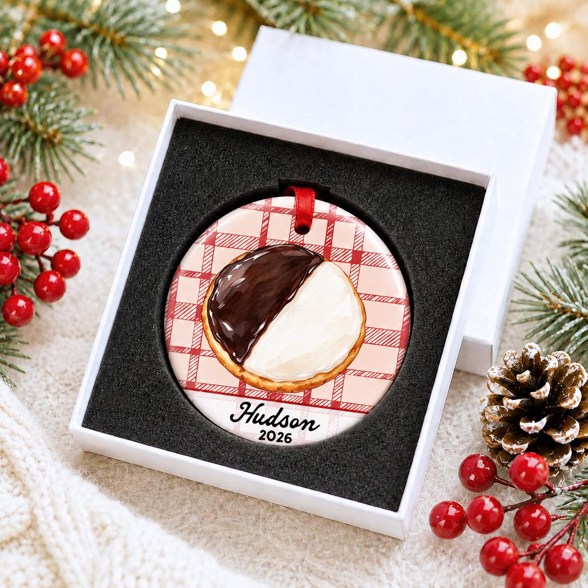 Personalized black and white cookie ceramic ornament with name and year on red plaid in a white gift box with protective foam