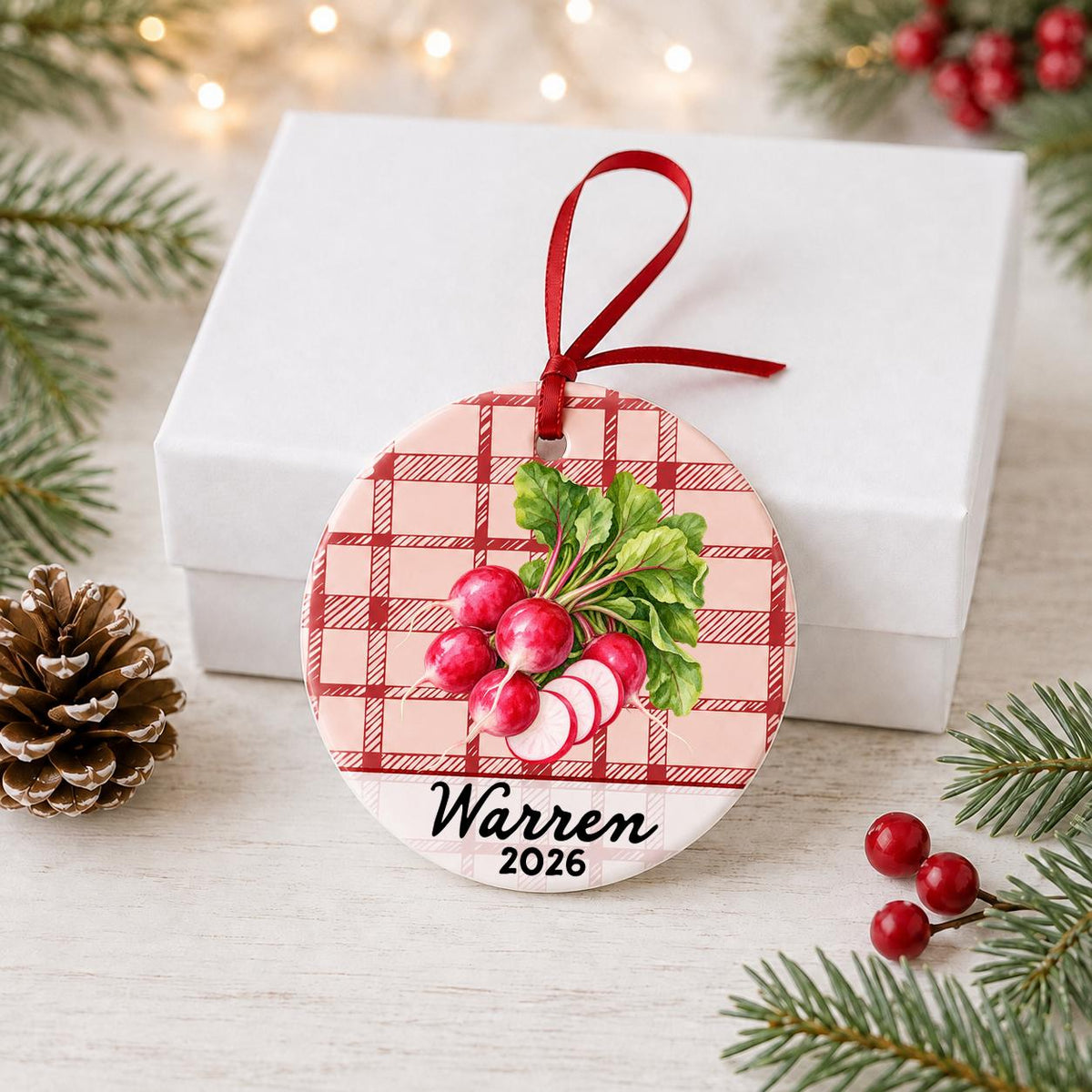 Personalized radishes ceramic ornament with name and year on red plaid in front of a white gift box with pinecones and red berries