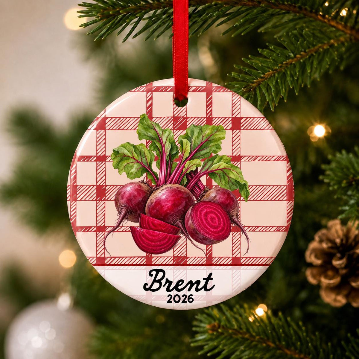 Close-up of the personalized beets ceramic ornament with name and year on red plaid hanging on a Christmas tree