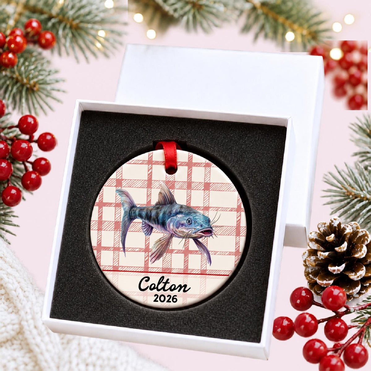 Personalized catfish ceramic ornament with name and year on red plaid in a white gift box with protective foam