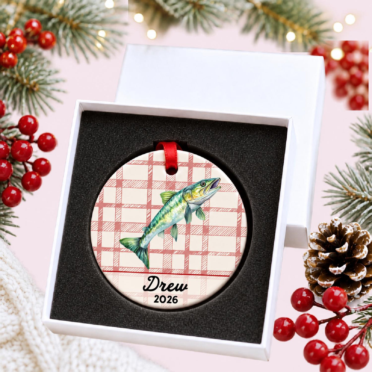 Personalized muskie ceramic ornament with name and year on red plaid in a white gift box with protective foam