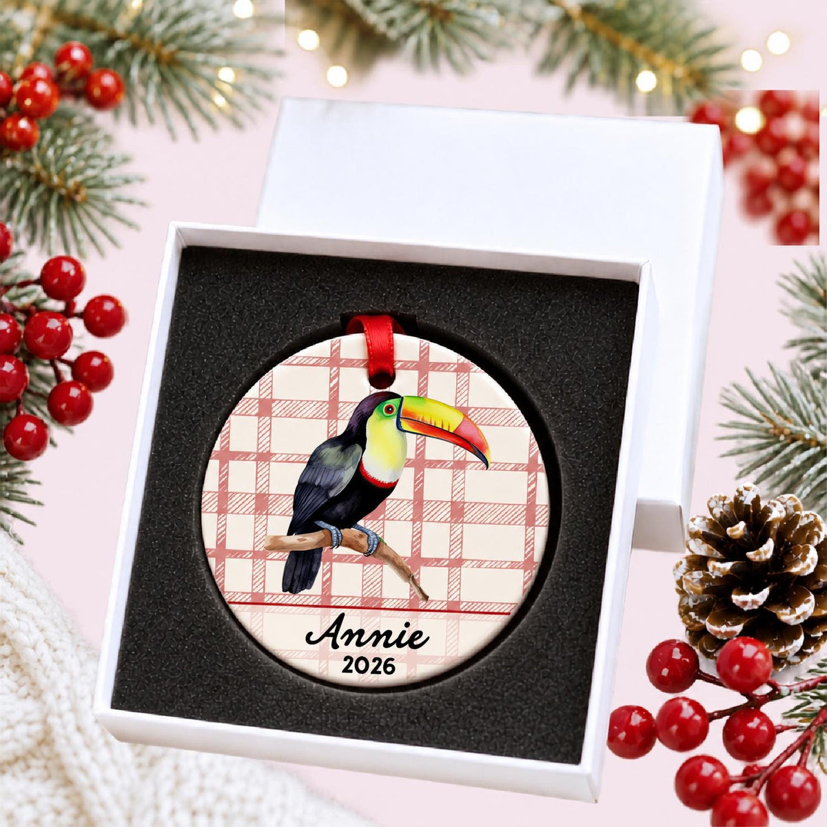 Personalized toucan ceramic ornament with name and year on red plaid in a white gift box with protective foam