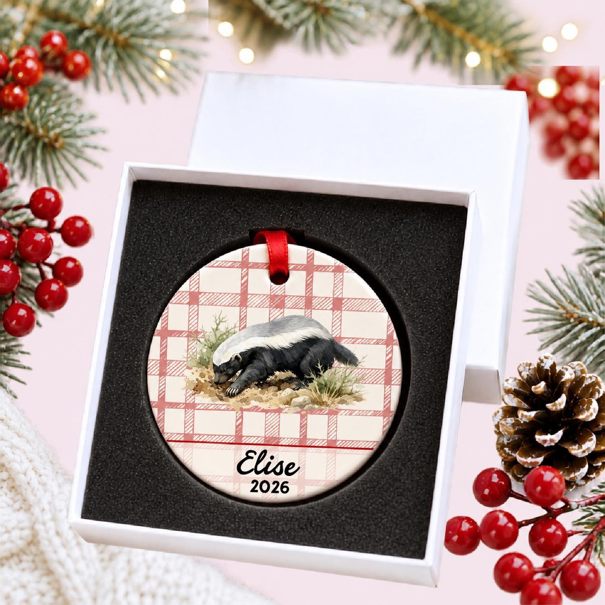 Personalized honey badger ceramic ornament with name and year on red plaid in a white gift box with protective foam
