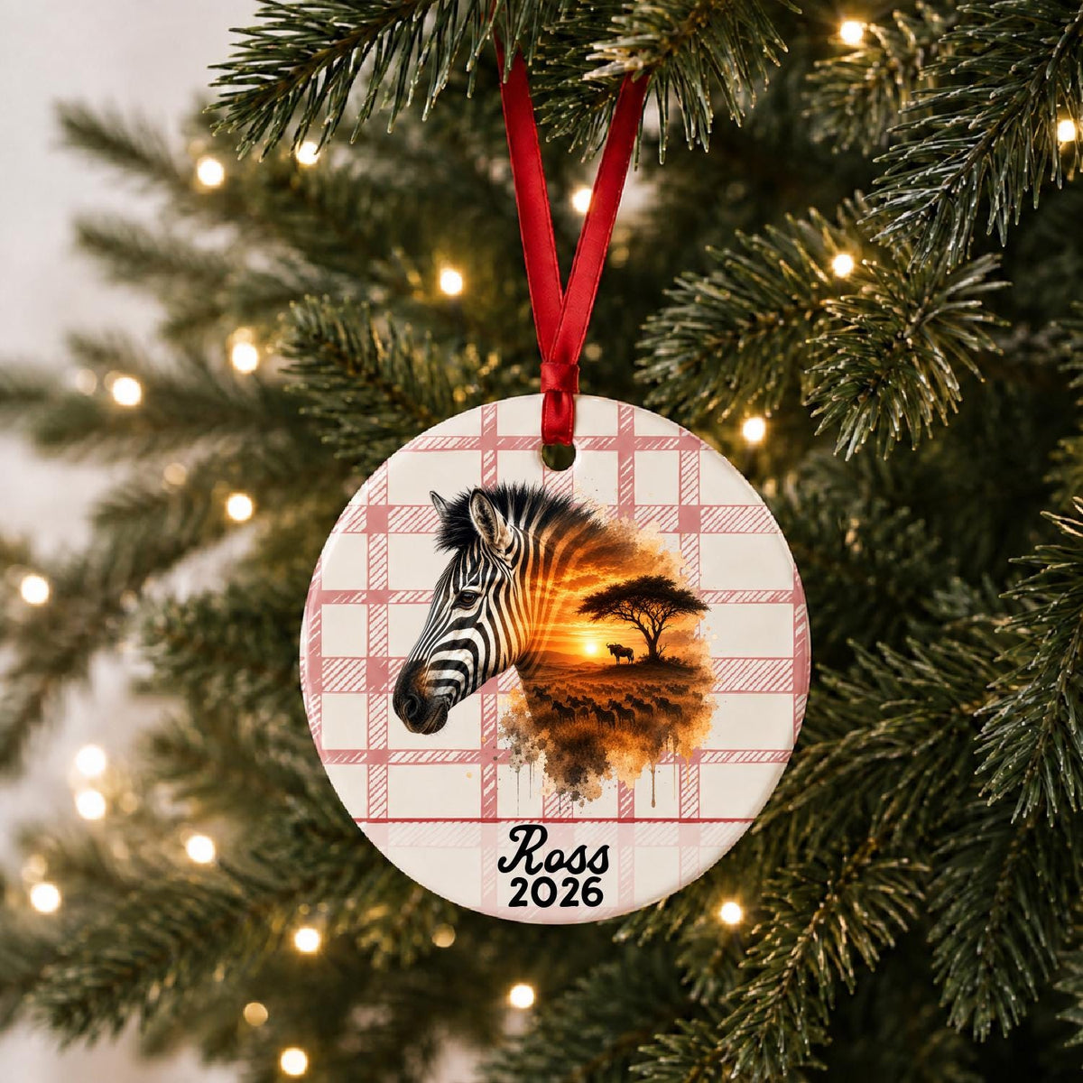 Personalized plains zebra ceramic ornament with name and year on red plaid hanging on a lit Christmas tree