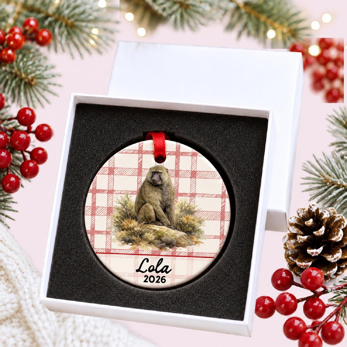 Personalized baboon ceramic ornament with name and year on red plaid in a white gift box with protective foam