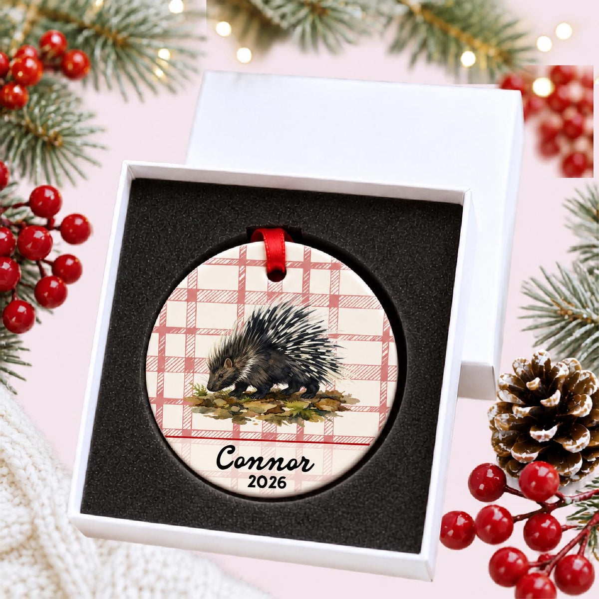 Personalized porcupine ceramic ornament with name and year on red plaid in a white gift box with protective foam