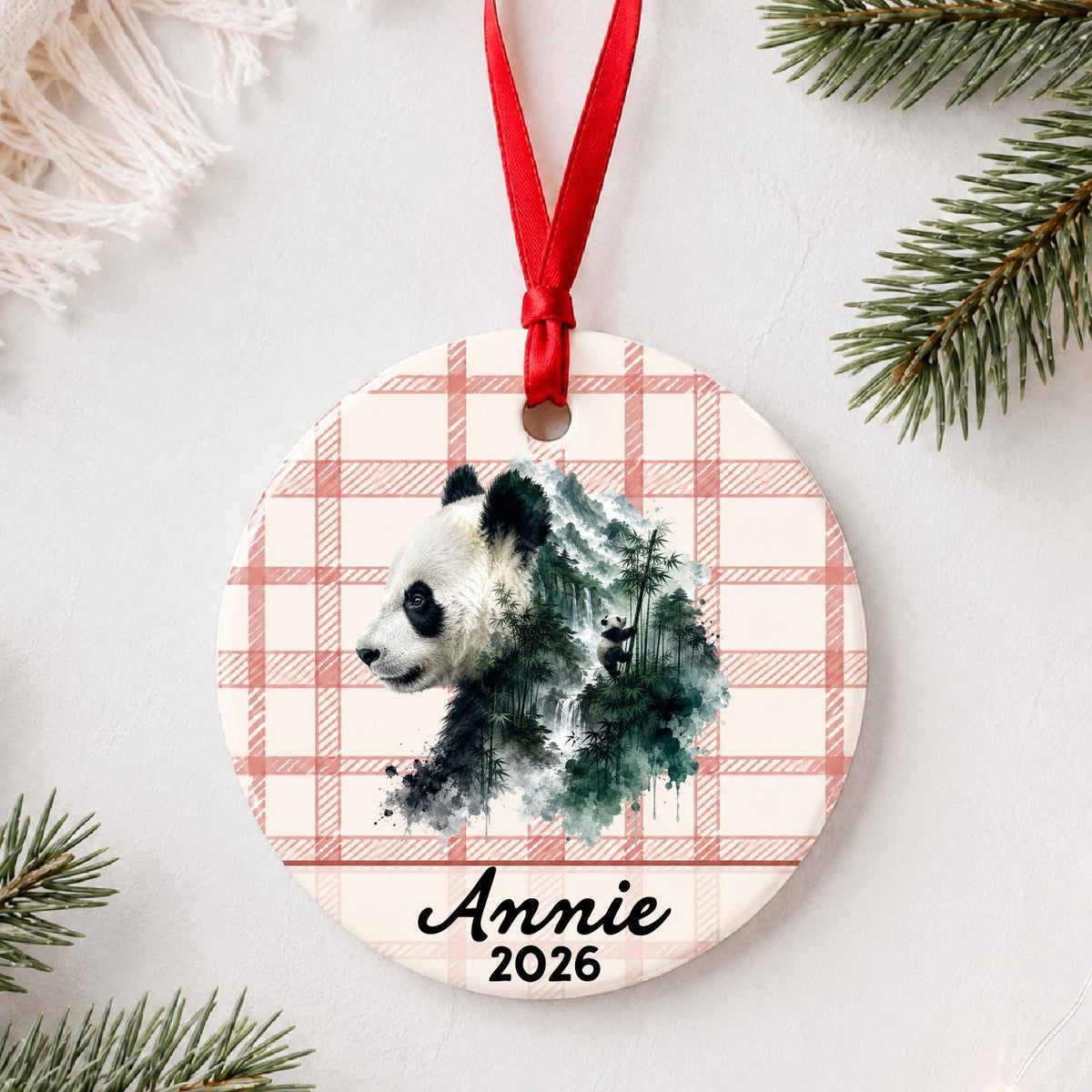 Personalized giant panda ceramic ornament with name and year on red plaid styled with pine branches on a soft white background