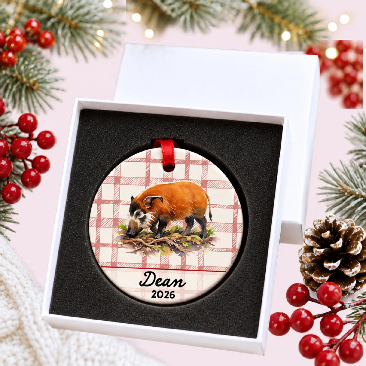 Personalized red river hog ceramic ornament with name and year on red plaid in a white gift box with protective foam