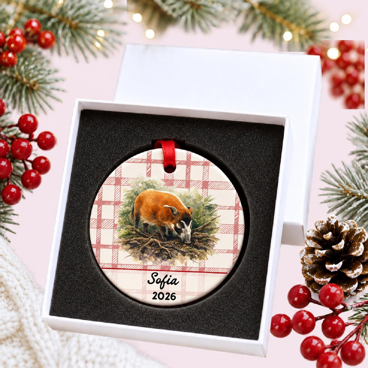 Personalized red river hog in forest ceramic ornament with name and year on red plaid in a white gift box with protective foam