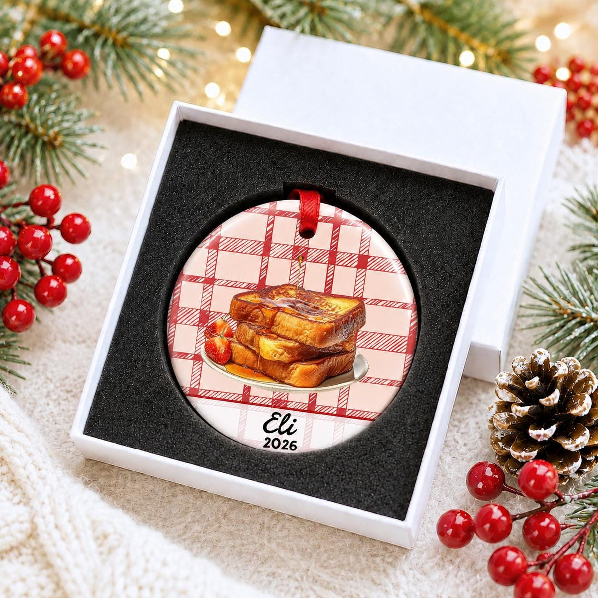 Personalized French toast ceramic ornament with name and year on red plaid in a white gift box with protective foam
