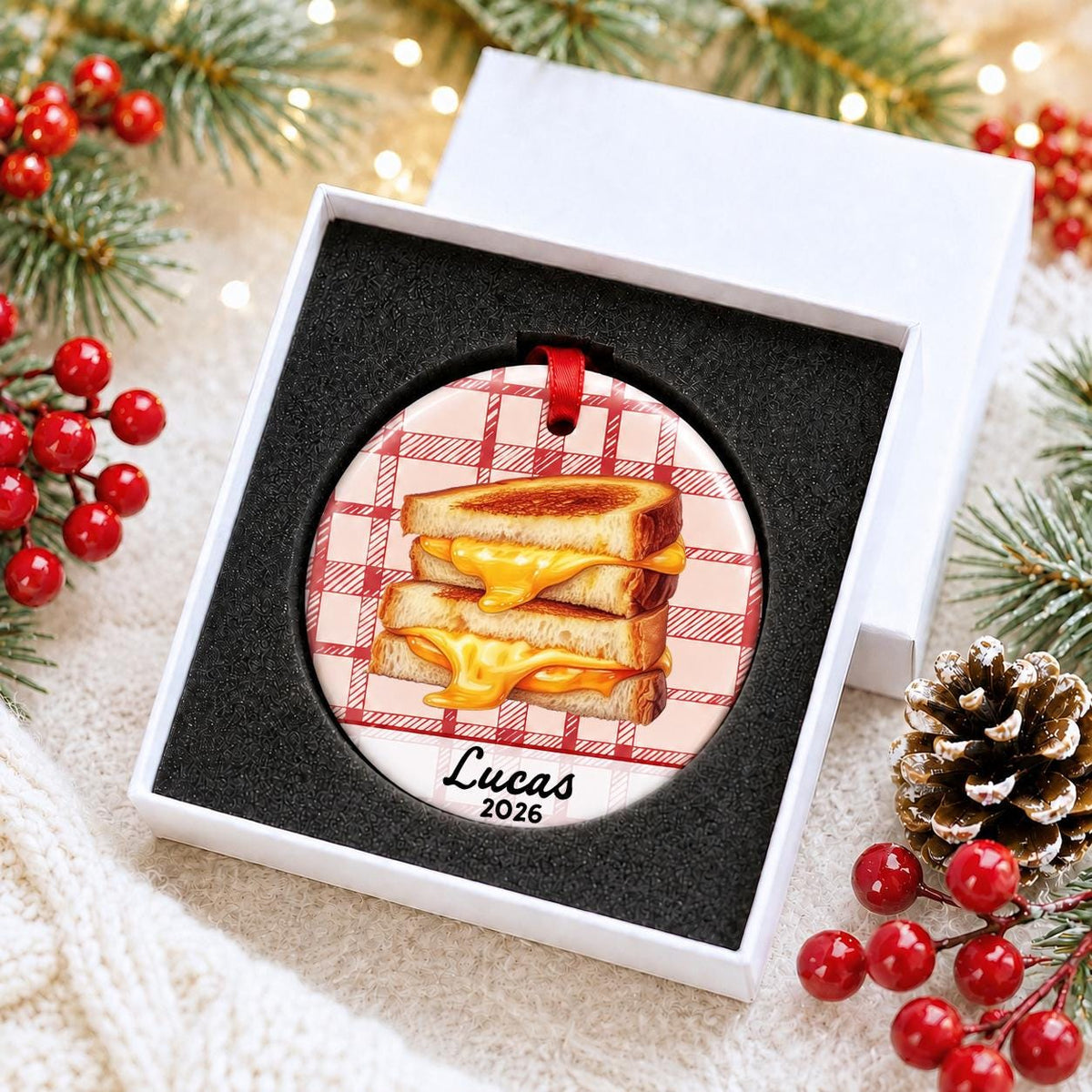 Personalized grilled cheese ceramic ornament with name and year on red plaid in a white gift box with protective foam