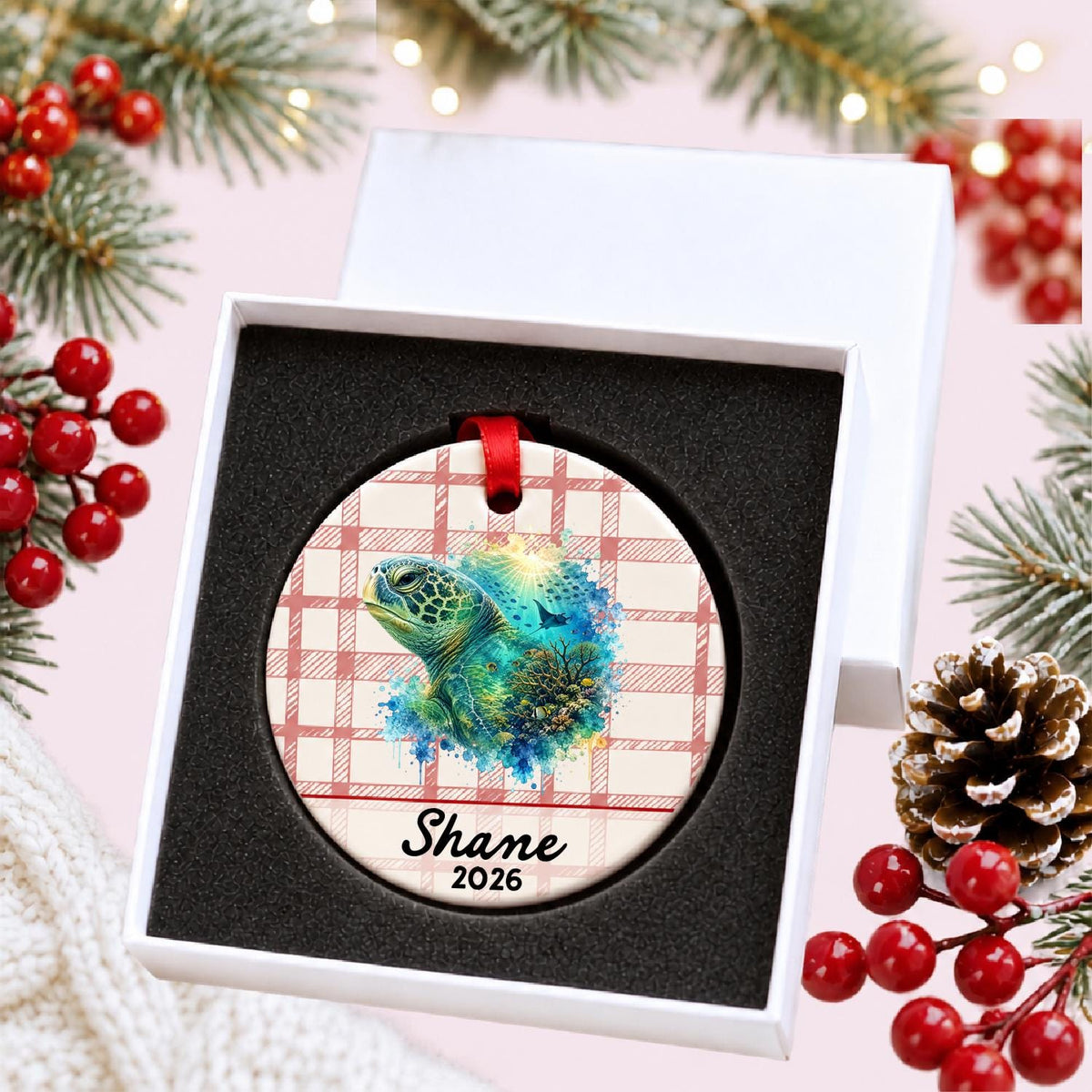 Personalized green sea turtle ceramic ornament with name and year on red plaid in a white gift box with protective foam