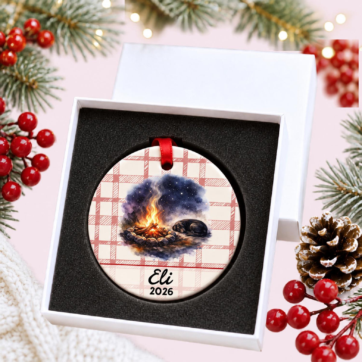 Personalized campfire and dog ceramic ornament with name and year on red plaid in a white gift box with protective foam