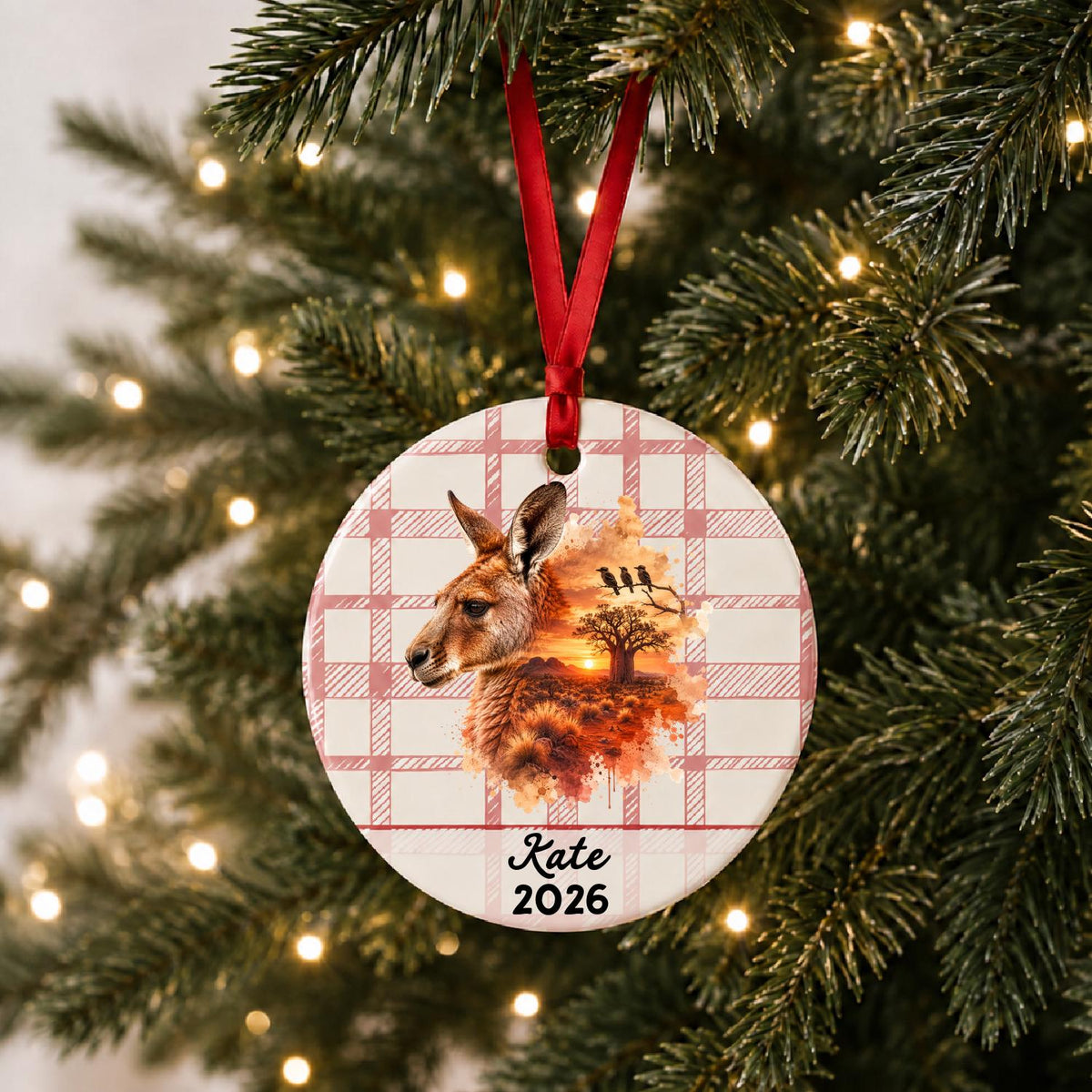 Personalized red kangaroo ceramic ornament with name and year on red plaid hanging on a lit Christmas tree