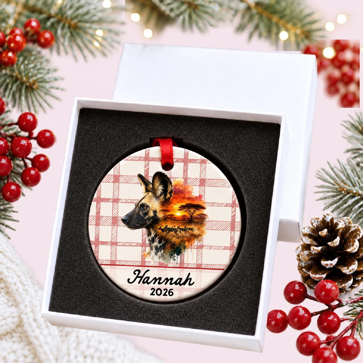 Personalized african wild dog ceramic ornament with name and year on red plaid in a white gift box with protective foam