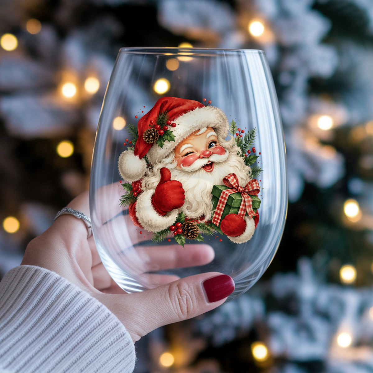 Winking Santa Claus With Gift UV DTF sticker applied to a stemless wine glass held in hand