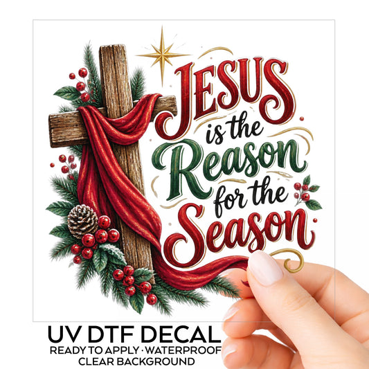 Jesus Is The Reason For The Season Cross UV DTF sticker on its backing card, held in hand