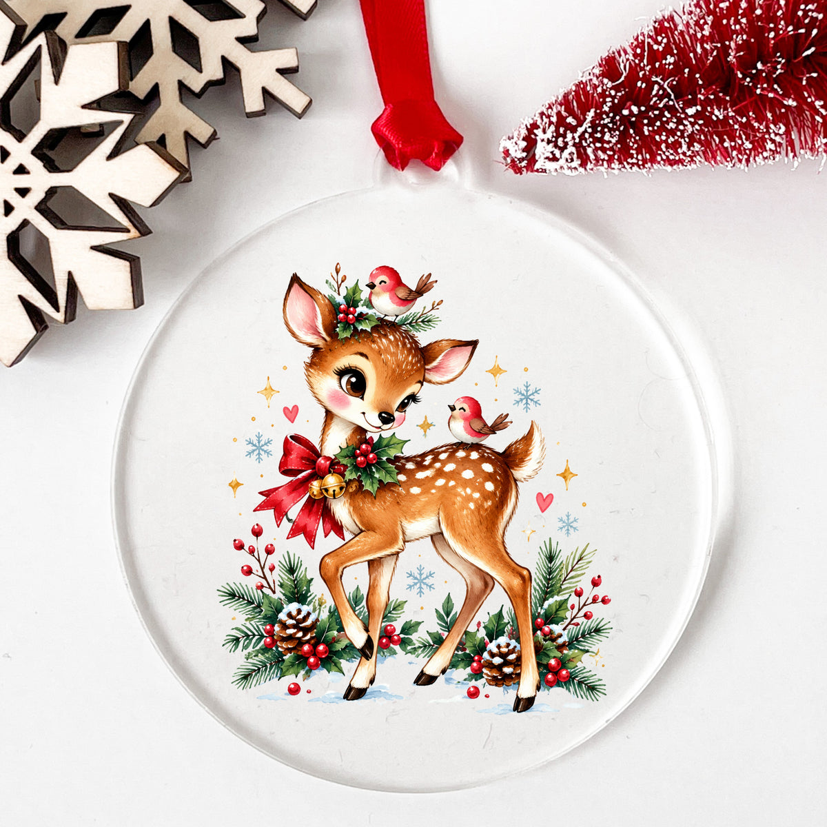 Christmas Deer With Red Cardinals UV DTF sticker applied to a clear round acrylic ornament with a red ribbon