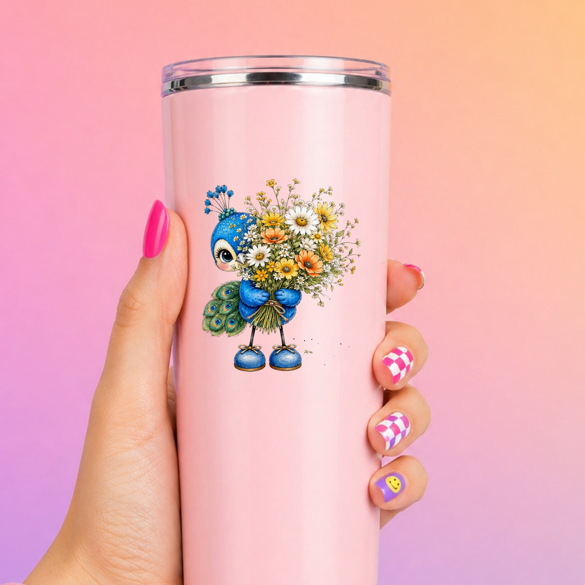 Peacock Holding Wildflower Bouquet UV DTF sticker applied to a tall pink tumbler on a pink and orange background