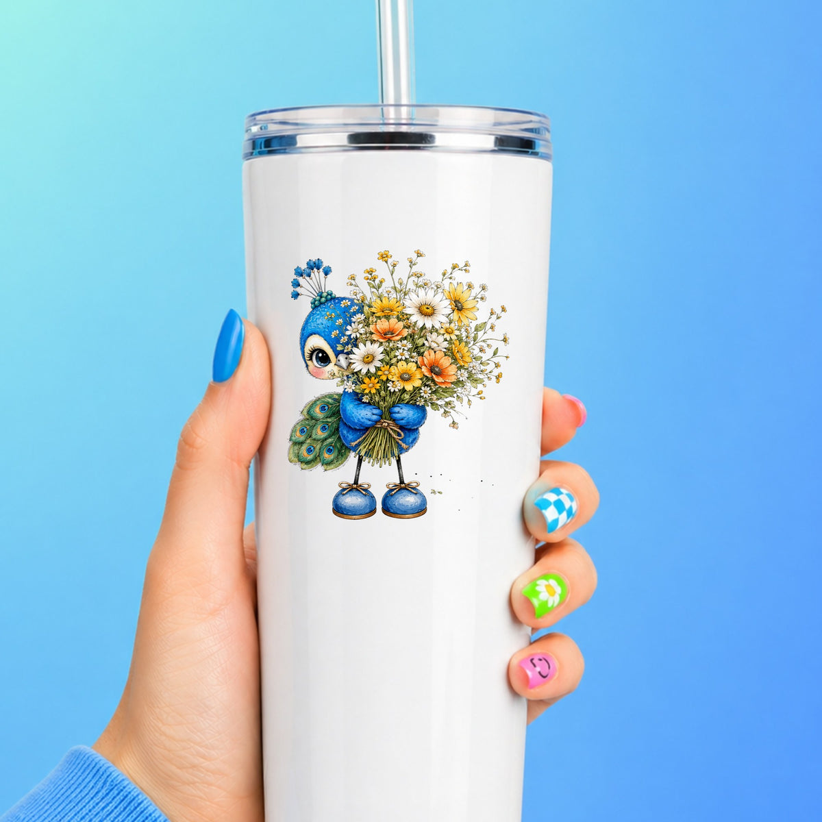 Peacock Holding Wildflower Bouquet UV DTF sticker applied to a white straw tumbler on a blue background