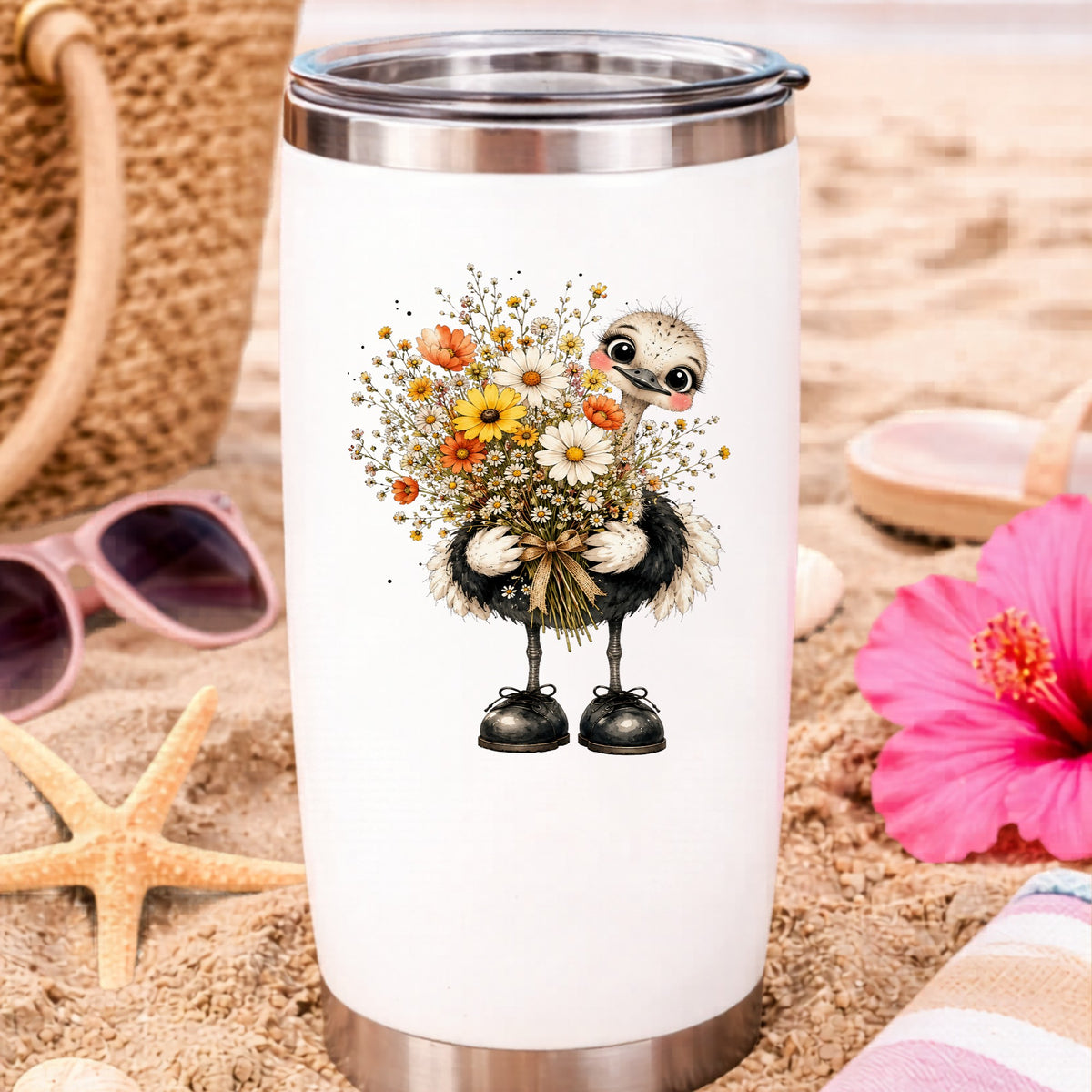 Ostrich Holding Daisy Bouquet UV DTF sticker applied to a white travel tumbler on beach sand