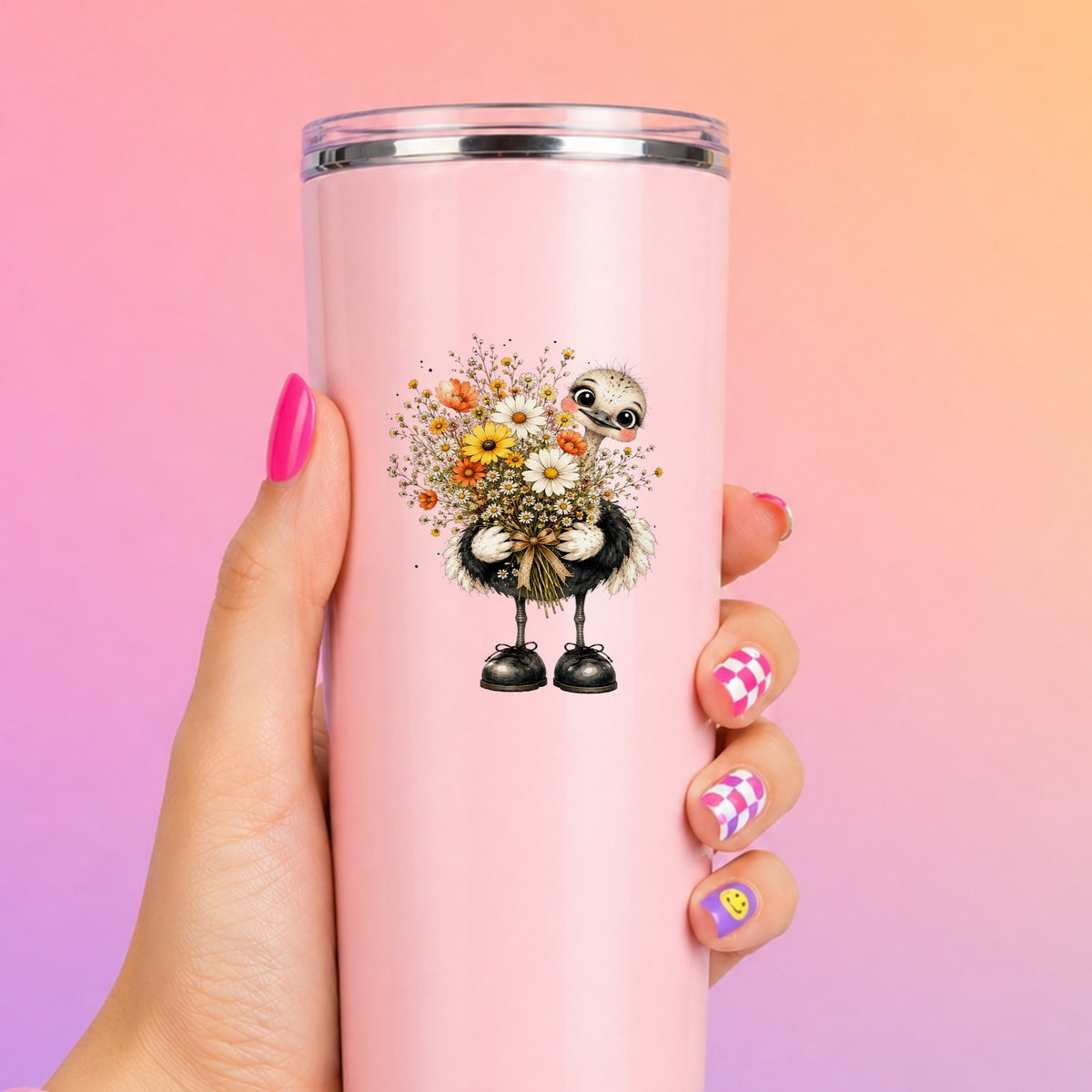 Ostrich Holding Daisy Bouquet UV DTF sticker applied to a tall pink tumbler on a pink and orange background