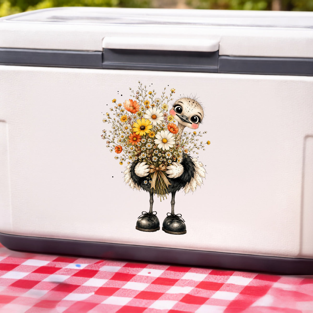 Ostrich Holding Daisy Bouquet UV DTF sticker applied to a white cooler on a red gingham cloth