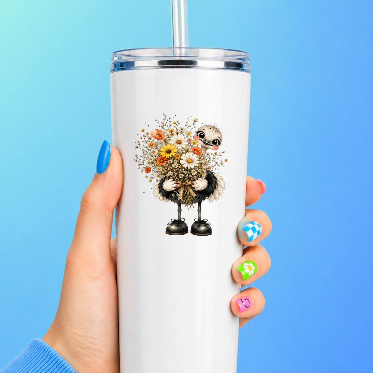 Ostrich Holding Daisy Bouquet UV DTF sticker applied to a white straw tumbler on a blue background