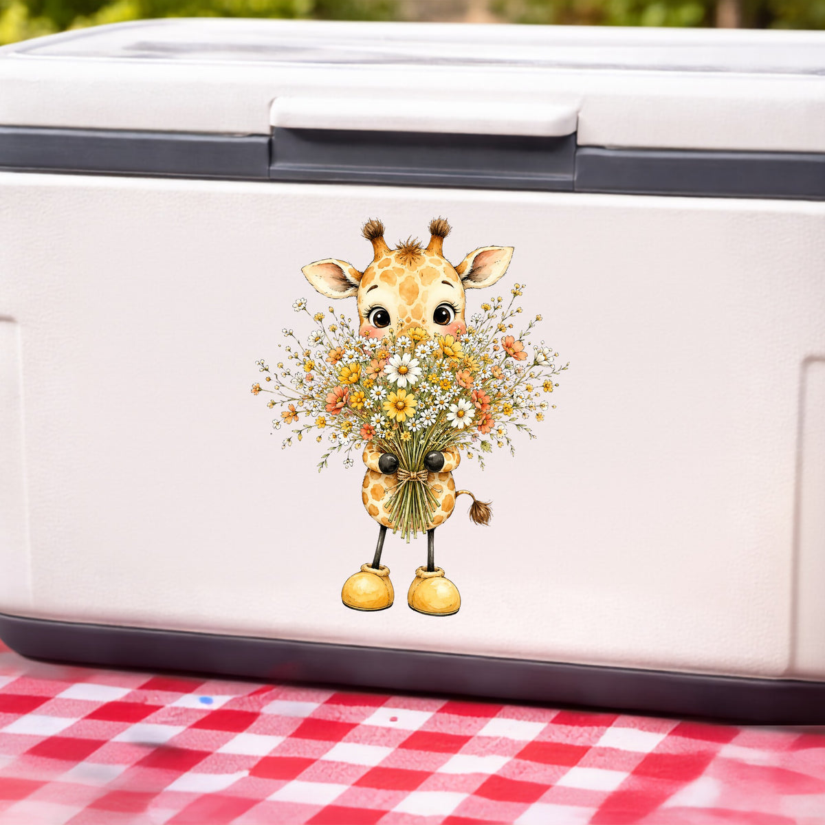 Baby Giraffe Holding Wildflower Bouquet UV DTF sticker applied to a white cooler on a red gingham cloth