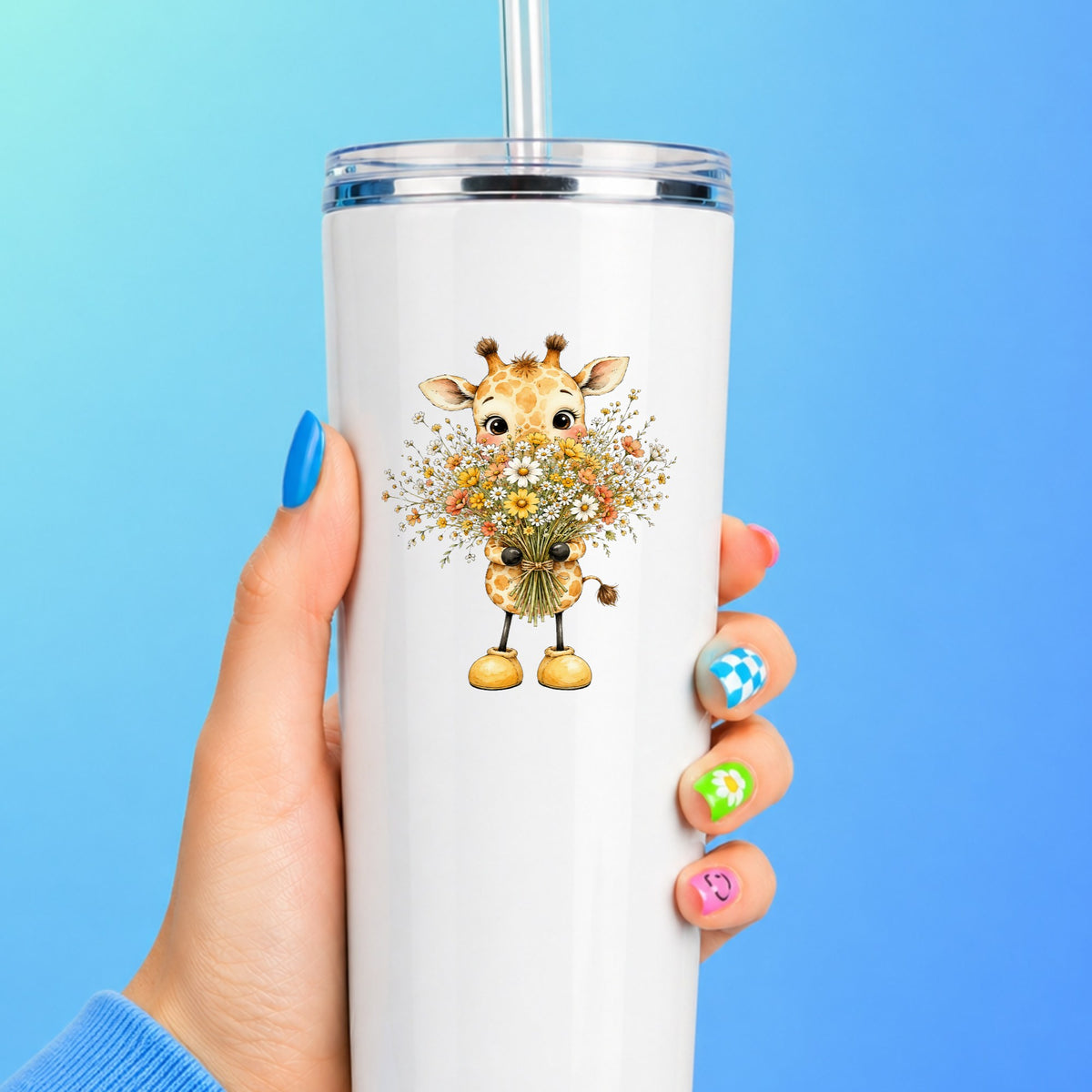 Baby Giraffe Holding Wildflower Bouquet UV DTF sticker applied to a white straw tumbler on a blue background