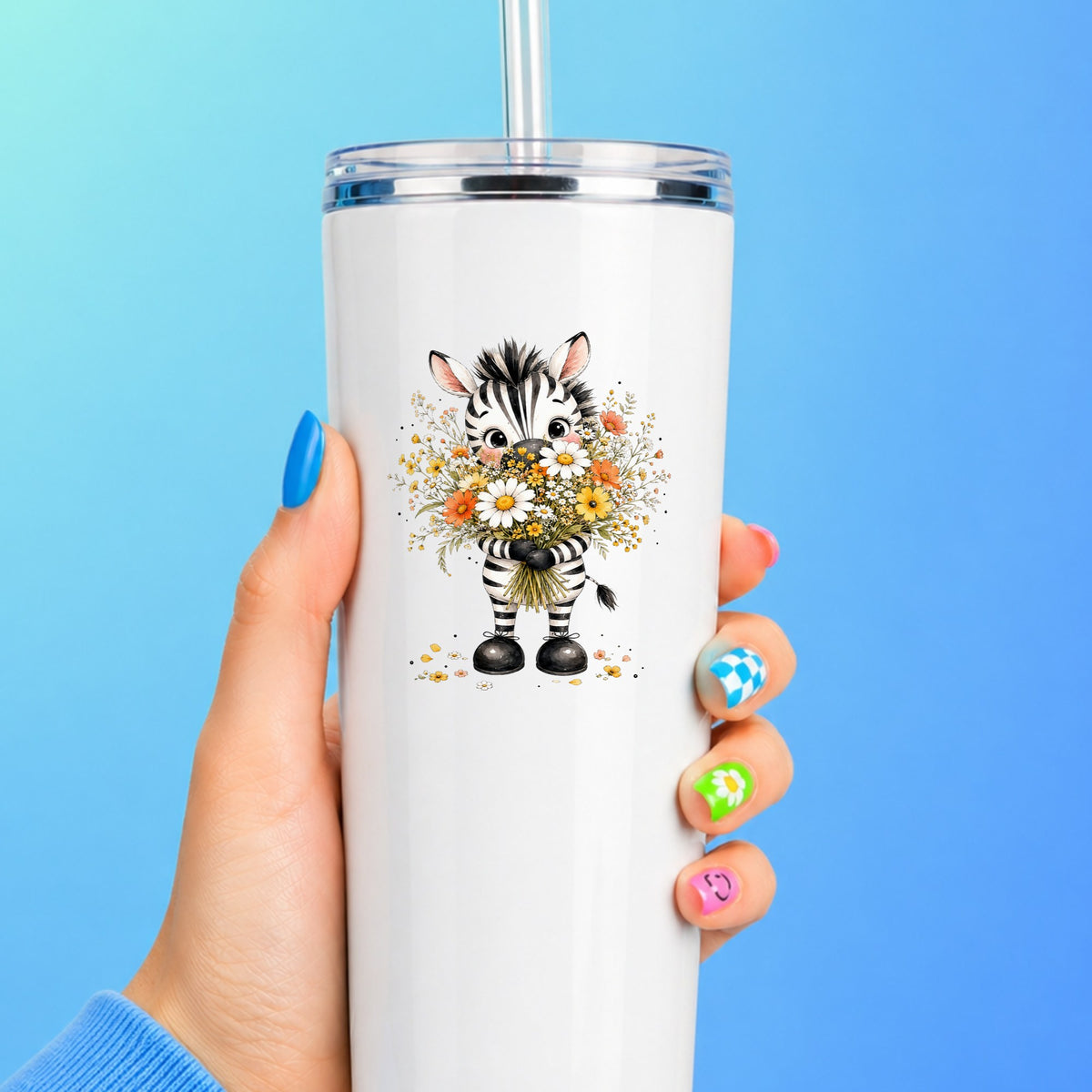 Zebra Holding Wildflower Bouquet UV DTF sticker applied to a white straw tumbler on a blue background