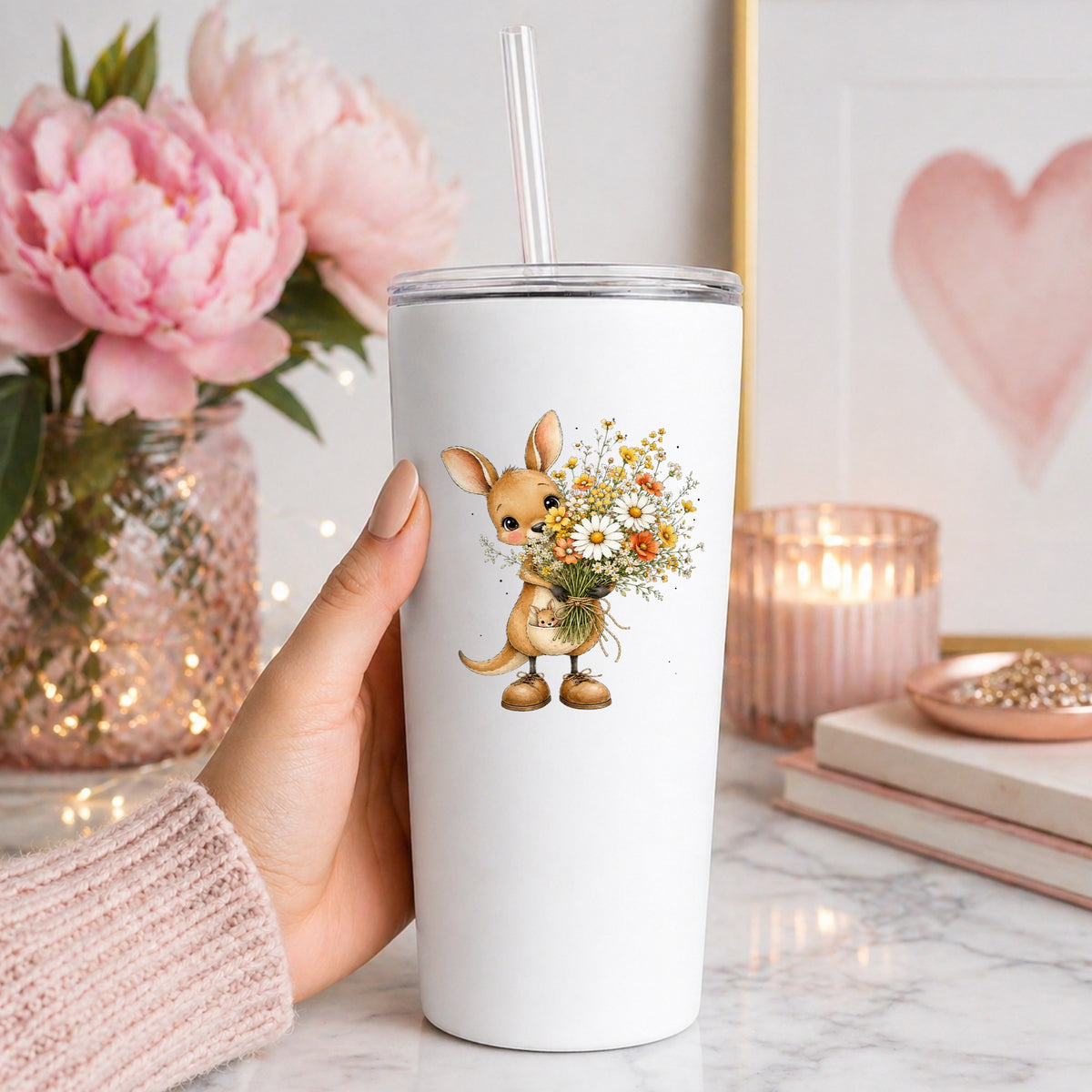 Kangaroo Holding Daisy Bouquet UV DTF sticker applied to a white straw tumbler beside pink peonies