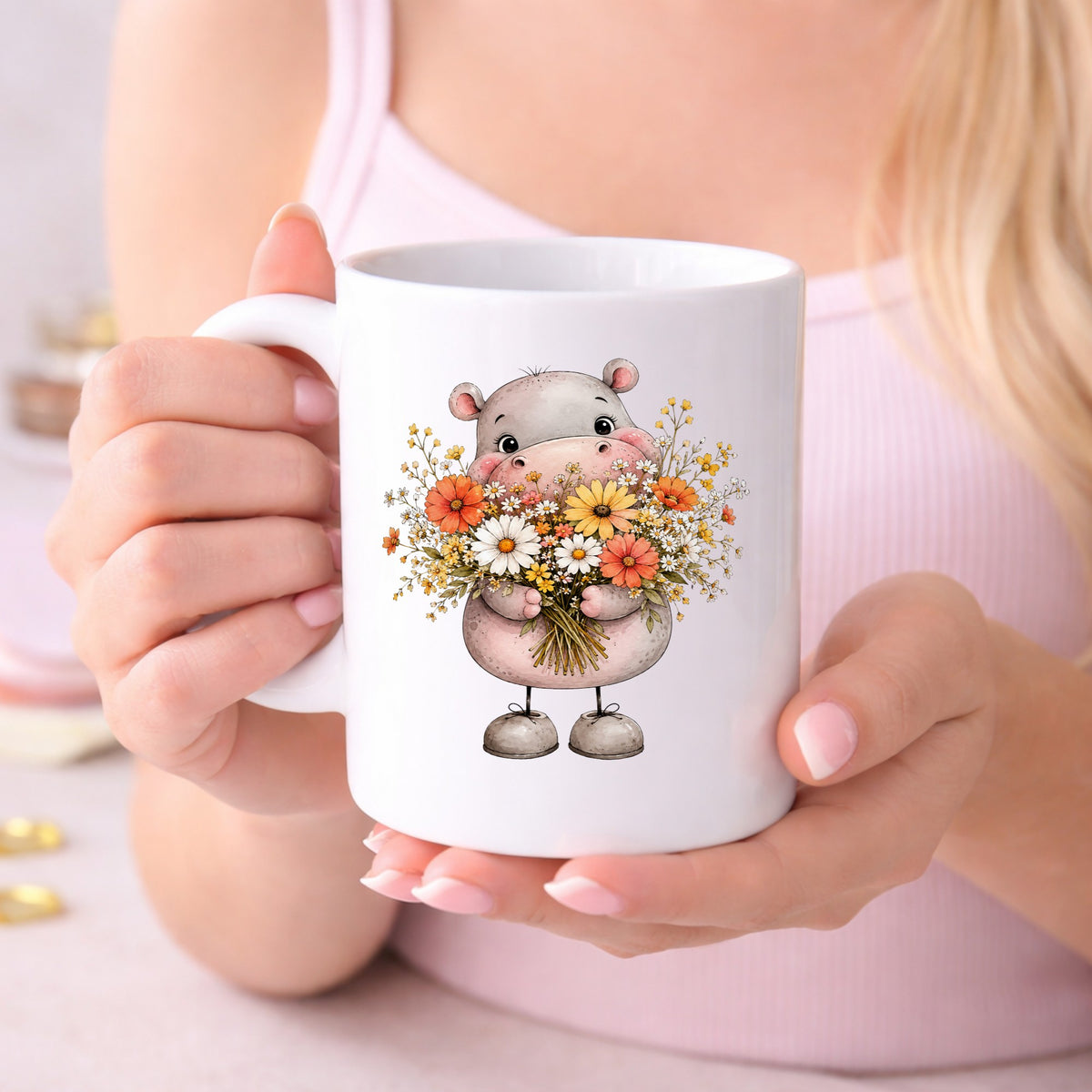 Pink Hippo Holding Wildflower Bouquet UV DTF sticker applied to a white coffee mug held in both hands