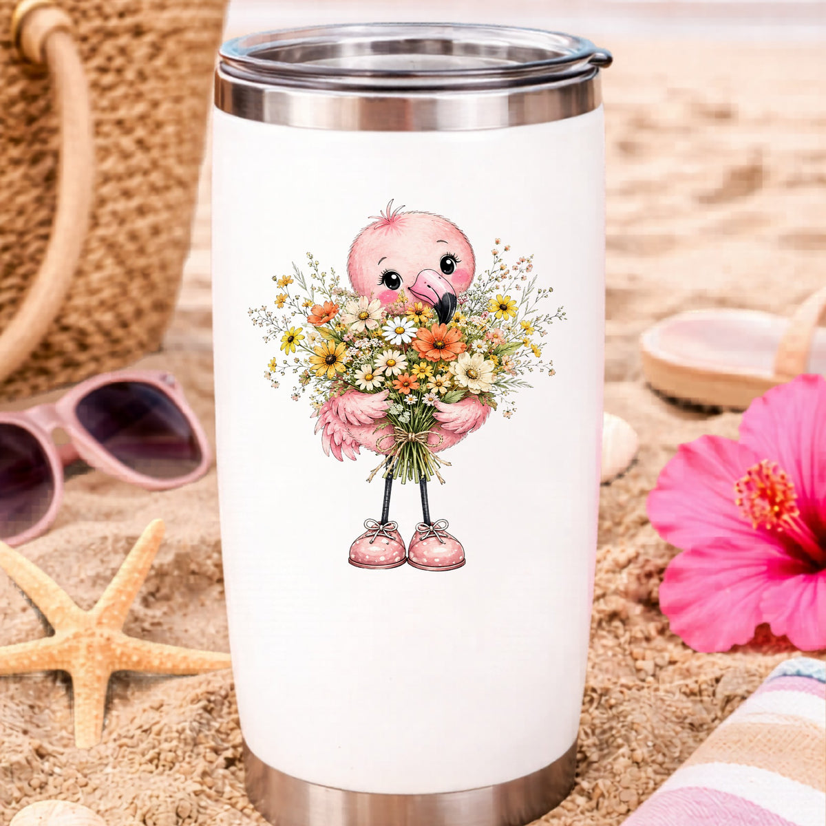 Pink Flamingo Holding Flower Bouquet UV DTF sticker applied to a white travel tumbler on beach sand