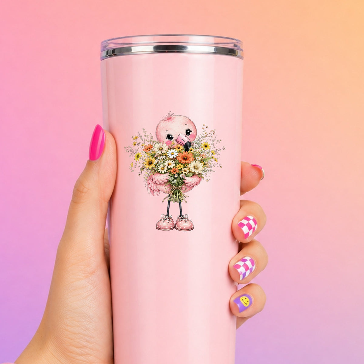 Pink Flamingo Holding Flower Bouquet UV DTF sticker applied to a tall pink tumbler on a pink and orange background