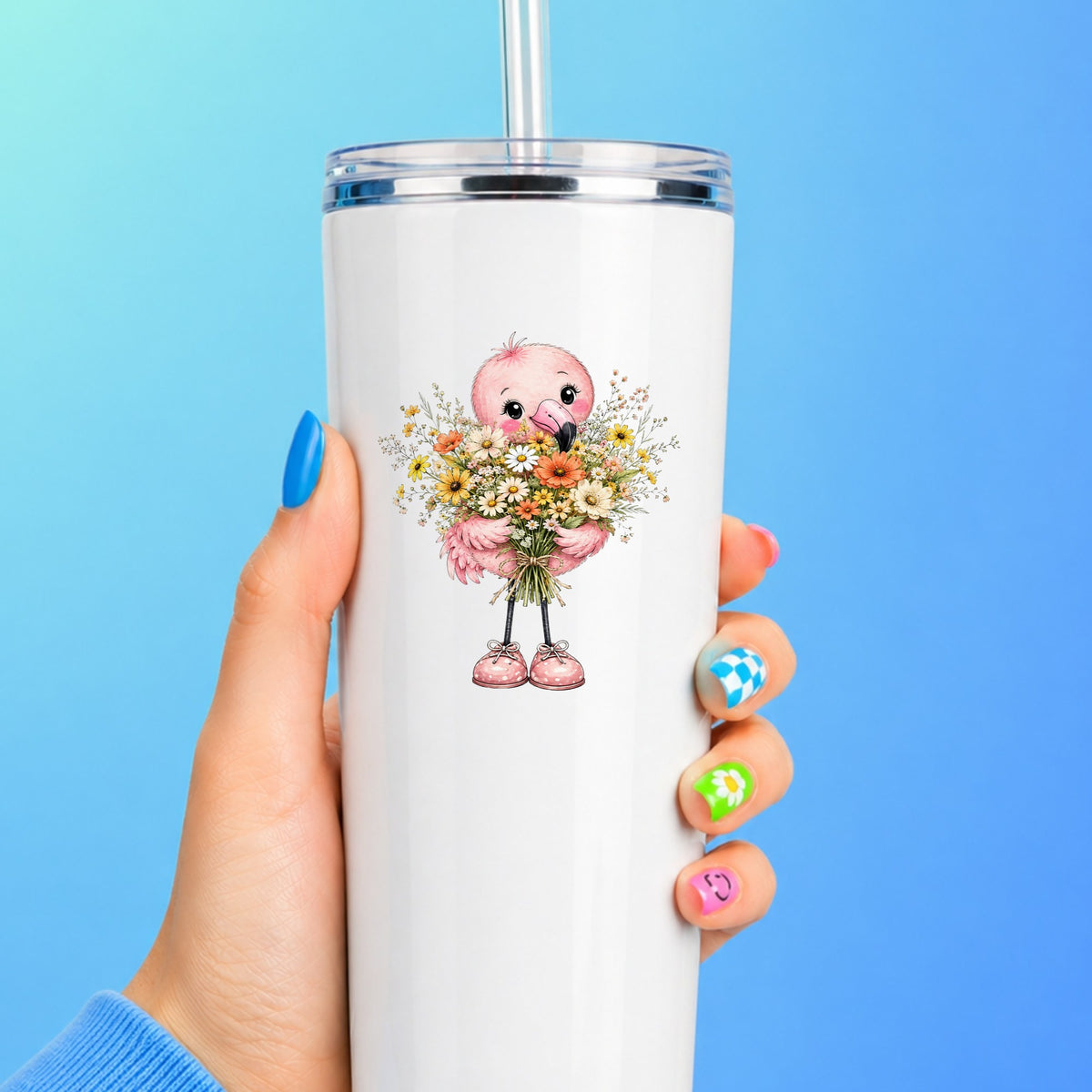 Pink Flamingo Holding Flower Bouquet UV DTF sticker applied to a white straw tumbler on a blue background