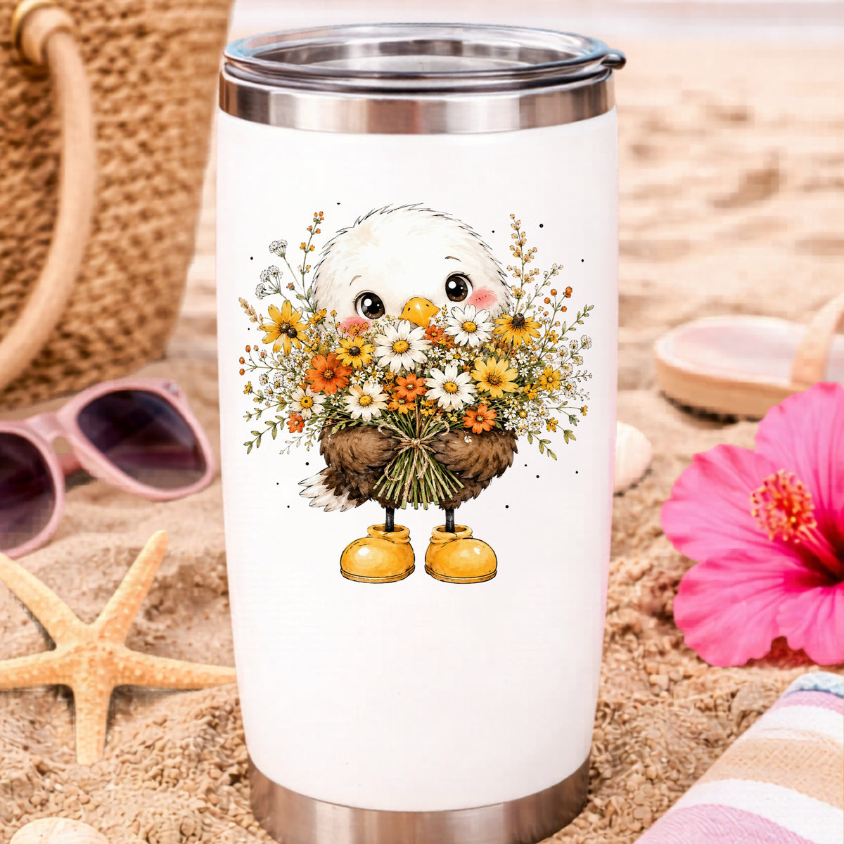 Baby Eagle Holding Daisy Bouquet UV DTF sticker applied to a white travel tumbler on beach sand