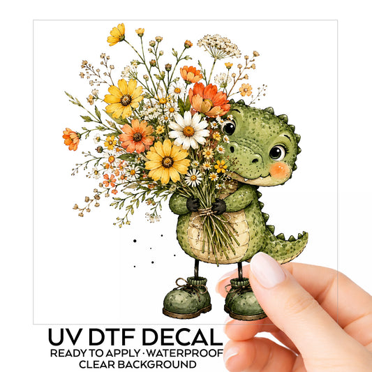Baby Crocodile Holding Flower Bouquet UV DTF sticker on its backing card, held in hand