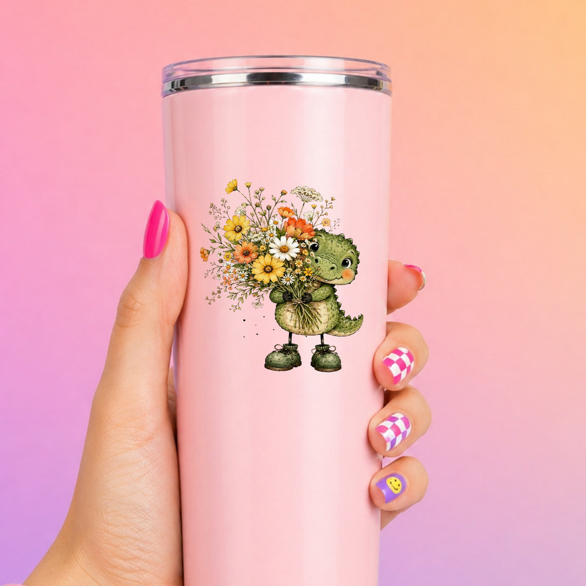 Baby Crocodile Holding Flower Bouquet UV DTF sticker applied to a tall pink tumbler on a pink and orange background