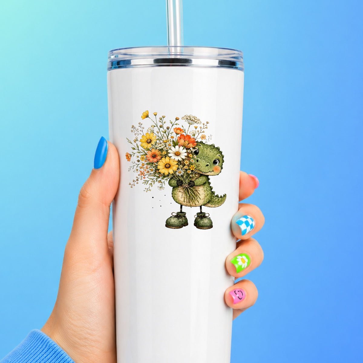 Baby Crocodile Holding Flower Bouquet UV DTF sticker applied to a white straw tumbler on a blue background